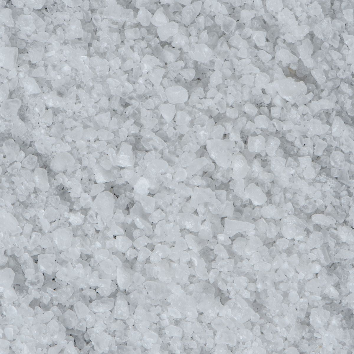 Close-up of Natrum muriaticum (sodium chloride) crystals showcasing coarse white salt granules covering the frame
