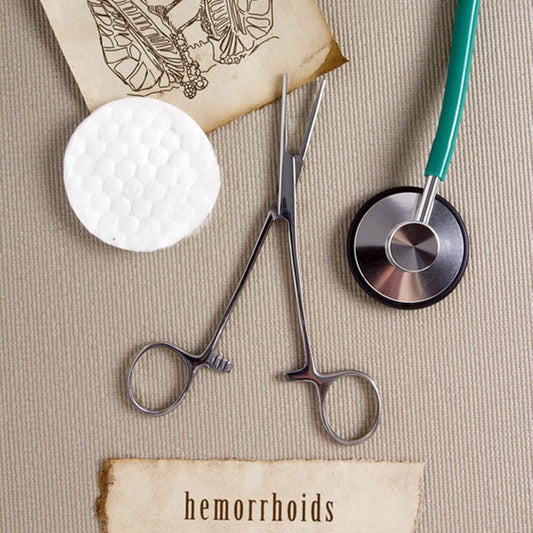Medical forceps and stethoscope near a hemorrhoids sign.