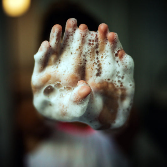 Woman holds soapy hands together while washing hands.