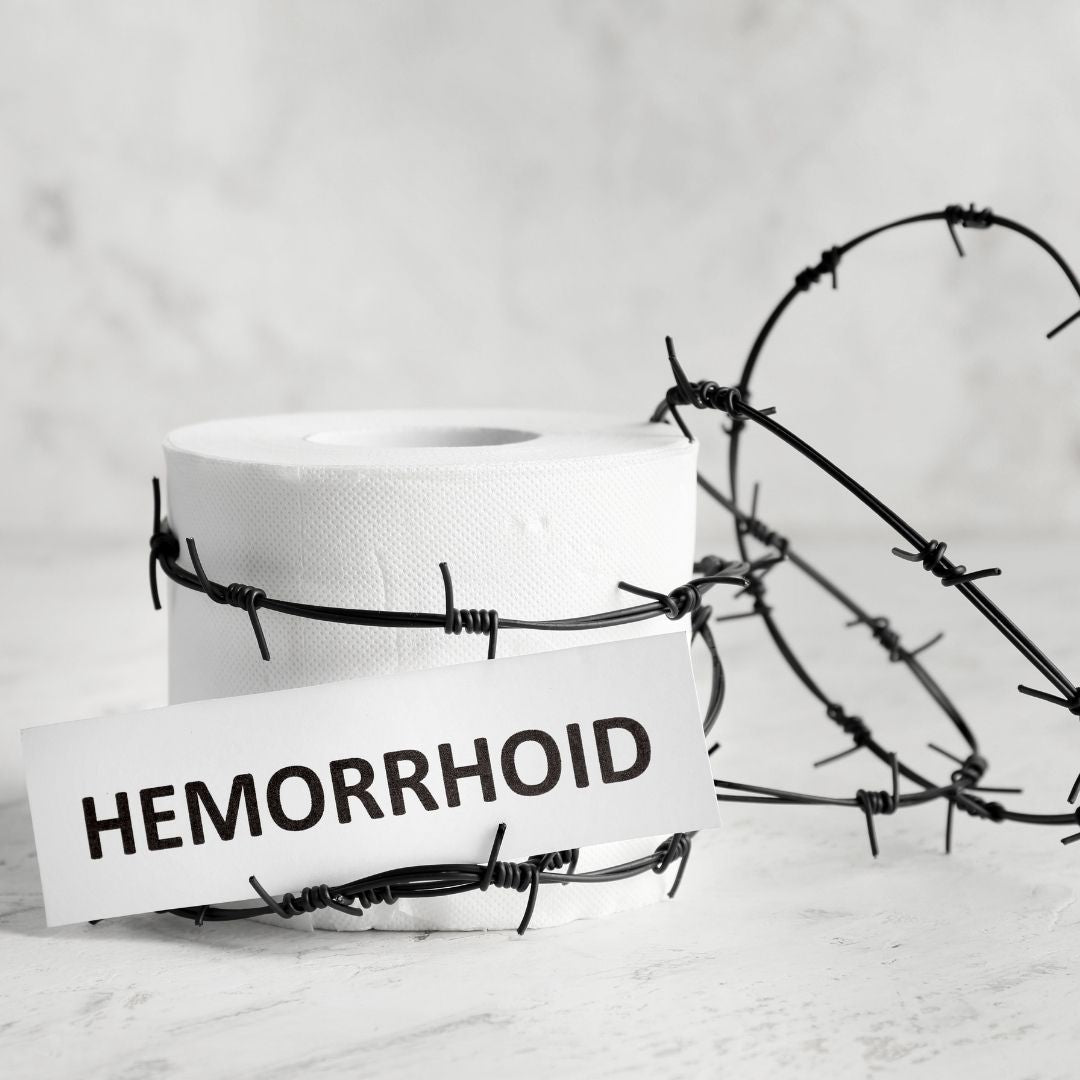 Toilet paper roll wrapped in barbed wire with label HEMORRHOID, symbolizing painful hemorrhoid symptoms