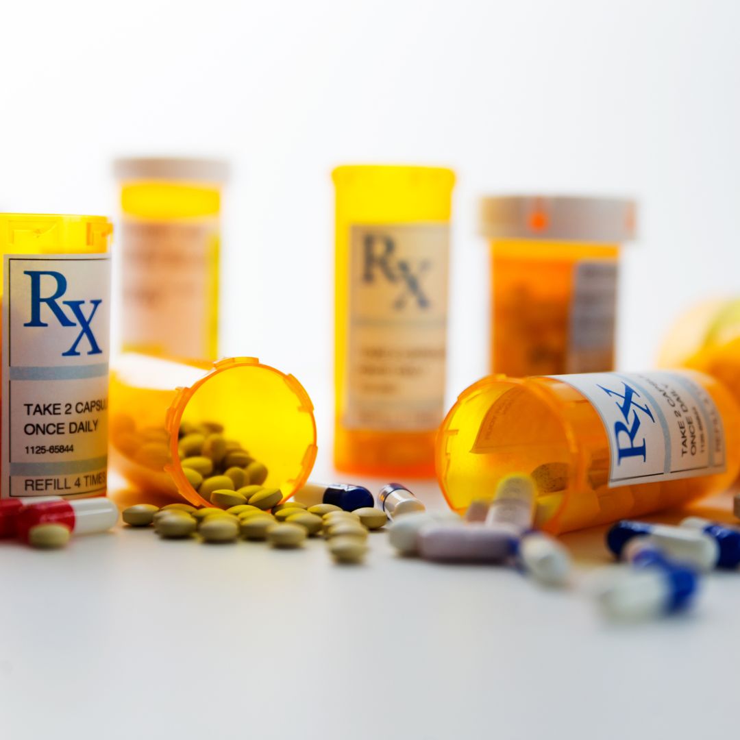 Prescription bottles spilled with pills on a white surface, illustrating medication use and possible adverse reactions
