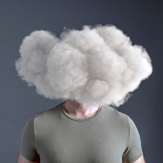 Man with a cloud covering his head, symbolizing brain fog and cognitive fatigue and brain fog, often linked to stress or poor sleep.