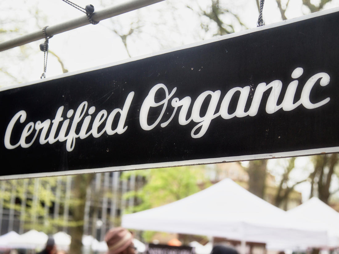Certified Organic sign that is black with white cursive writing. 